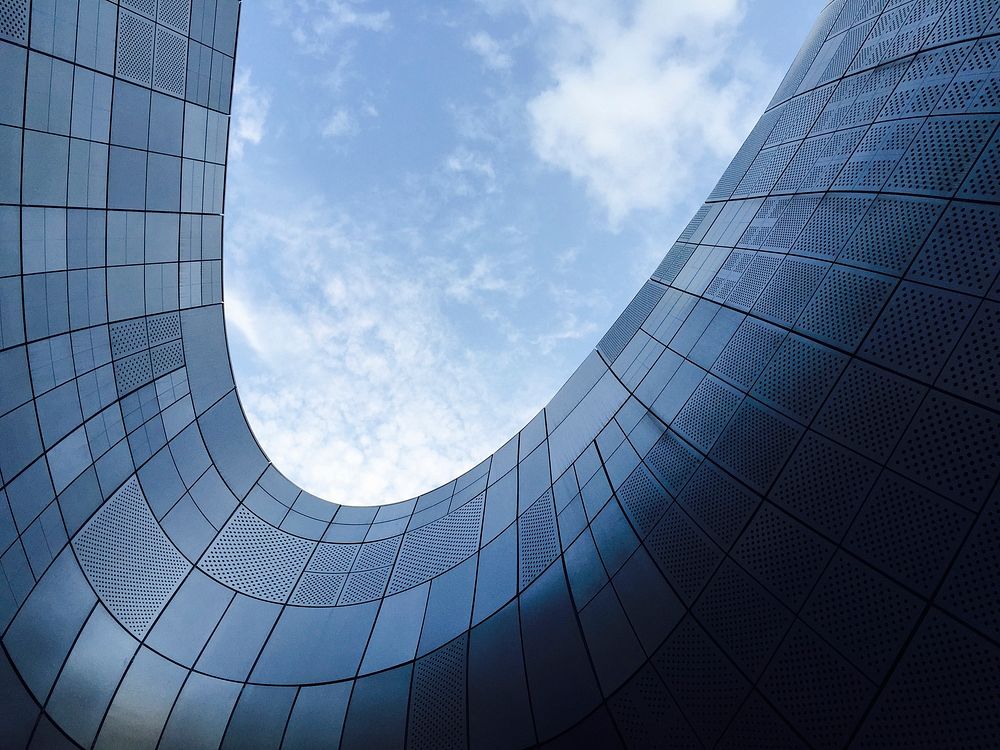 Modern glass architecture in Dongdaemun, Seoul, viewed from below.